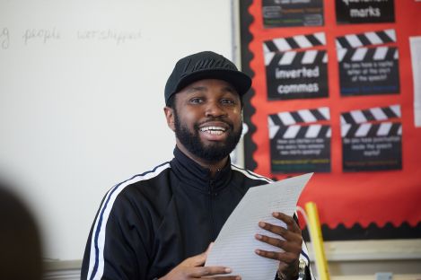 An adult with a piece of paper in a classroom