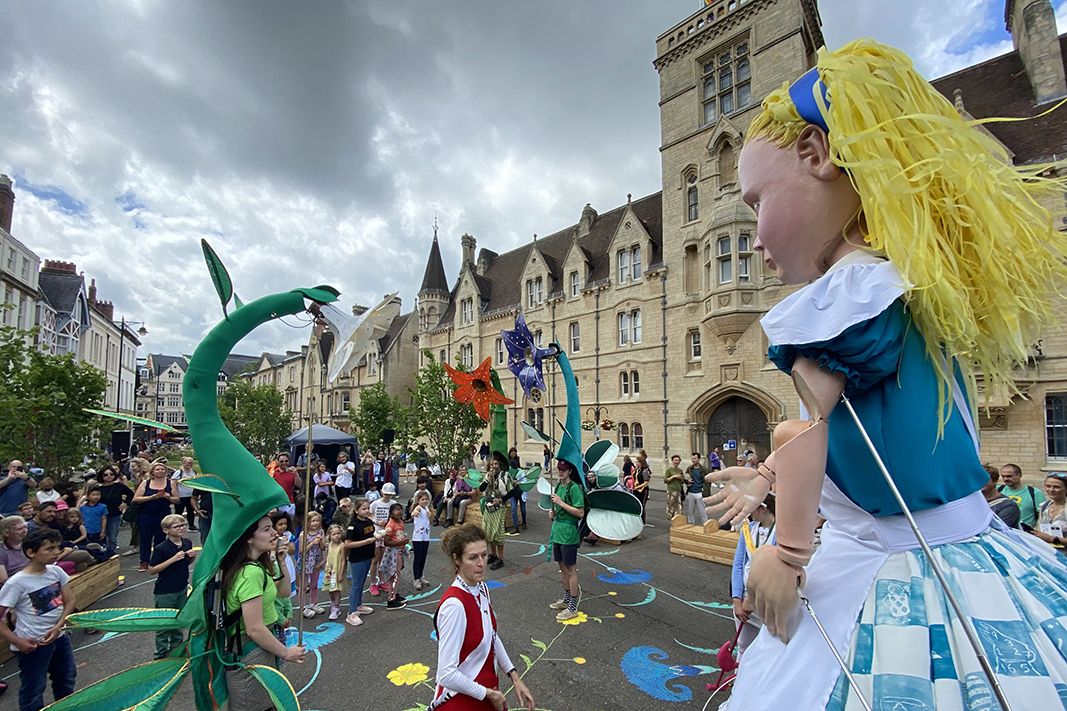 A giant puppet Alice and a crowd