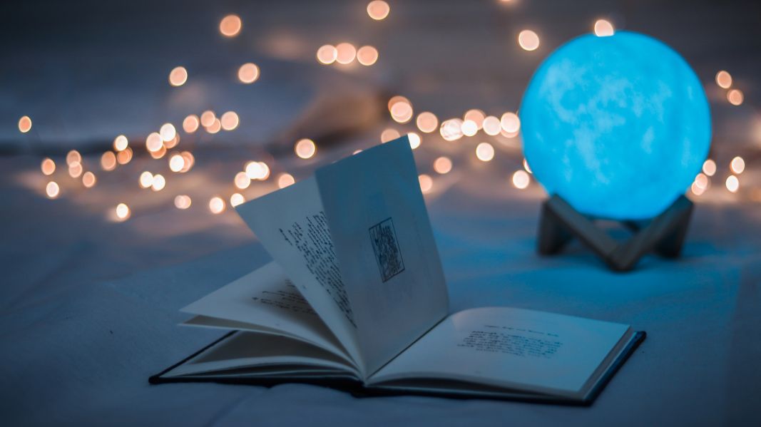 An open book with fairy lights in the background