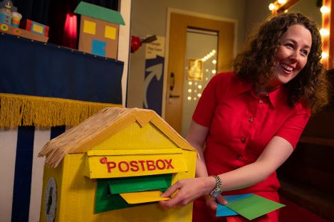 Storyteller posting letters in a toy postbox