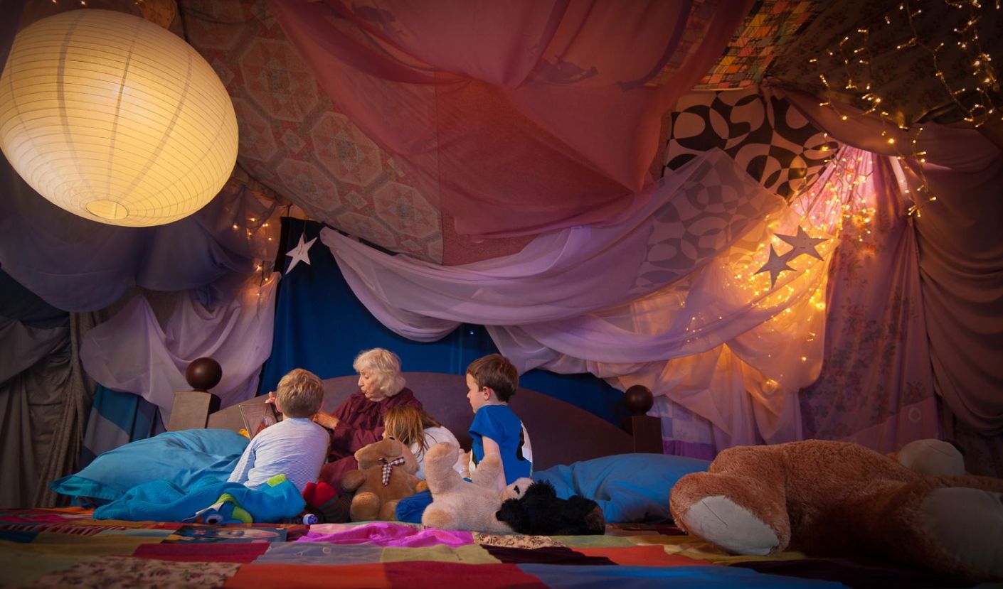 Children and a grown up sitting on our giant bed