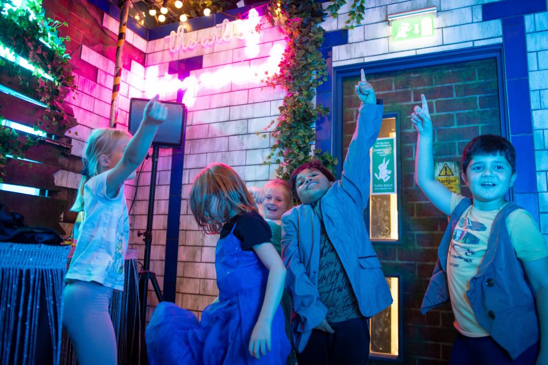 Children dancing in neon lights at The Story Museum