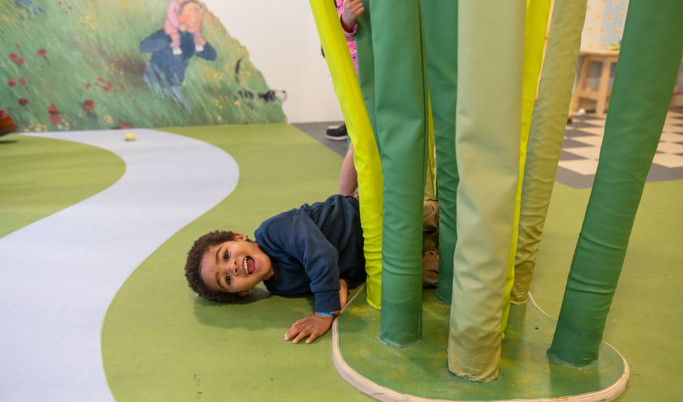 A boy lying in fake grass.