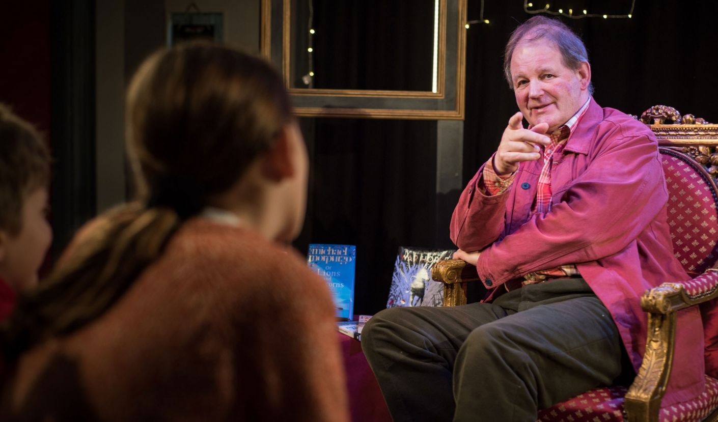 Michael Morpurgo sitting in a chair talking to an audience
