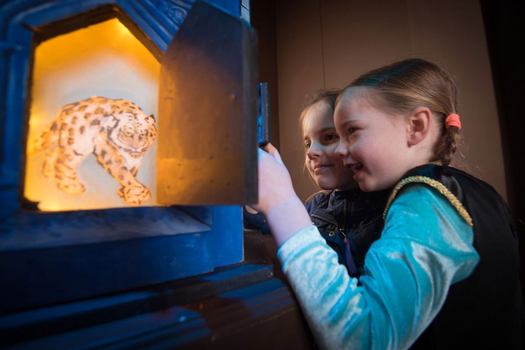 Two young children looking into a museum display