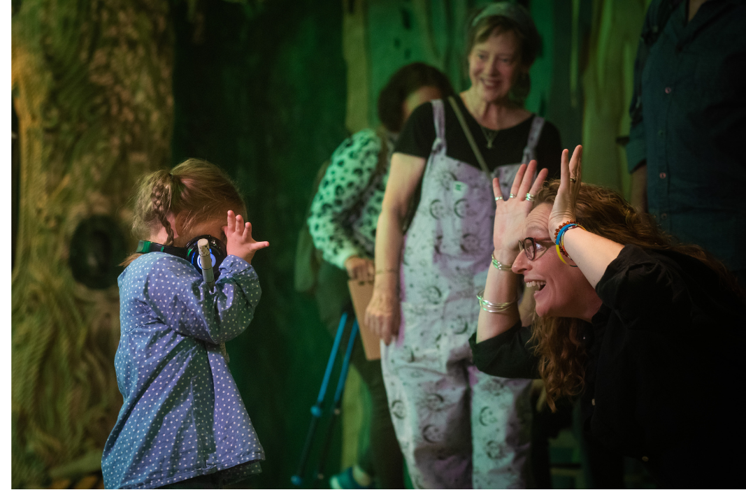 A parent and child playing Peekaboo in the Whispering Wood